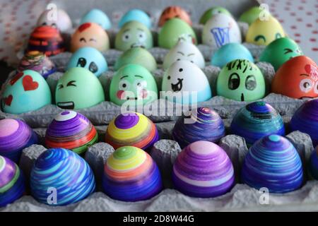 Easter eggs colored in pastels and vivid colors and decorated with funny stickers and markers Stock Photo