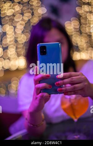 Woman using her mobile phone with blurred background Stock Photo