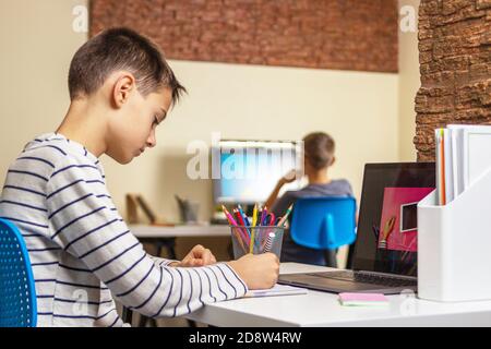 Online learning, remote education, distance learning, entertiment at home. Kids using laptop computers for homework Stock Photo