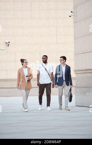 Three young intercultural managers chatting about their plans for the evening Stock Photo