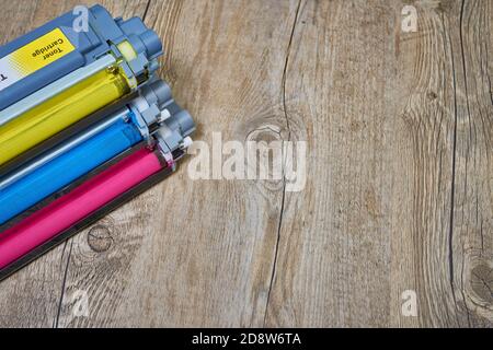 Magenta, yellow and cyan toner cartridges for a color laser printer on wood Stock Photo