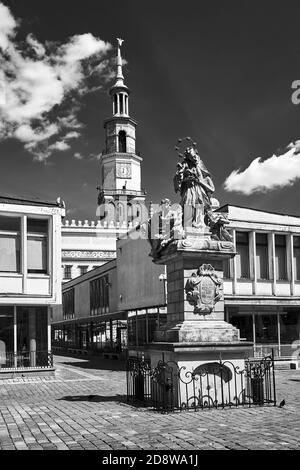 The historic figure of St. John of Nepomuk and the town hall tower in the market square in Poznan, monochrome