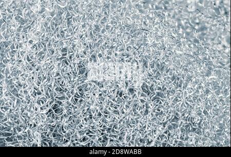 Heap of spiral twisted metal chips of alu alloy in silver-blue toned background. Abstract texture of shiny dural swarf tangle. Turning by-product. Eco. Stock Photo