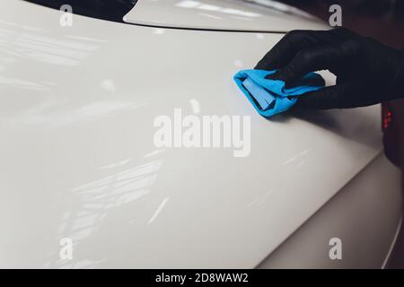 Car detailing - Man applies nano protective coating to the car. Selective focus. Stock Photo