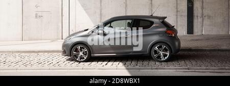 Katowice/Poland-05.05.2016: Grey Peugeot 208 GTI with original matt varnish standing under the concrete wall of the Silesian Museum. Cult hot hatch, f Stock Photo