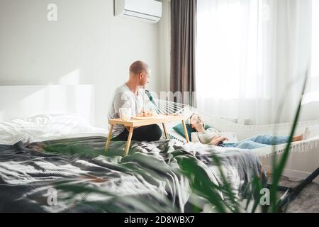 Happy couple having a good time at home. Young family spend time make fun while sitting at home Stock Photo