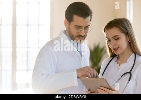 Two doctors male and female colleagues working on digital tablet Stock Photo