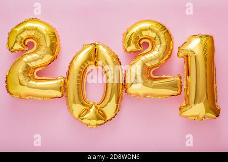 2021 balloon text on pink background. Happy New year eve invitation with Christmas gold foil balloons 2021. Flat lay long web banner Stock Photo