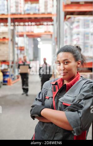 Successful young mixed-race female worker of large warehouse crossing arms Stock Photo