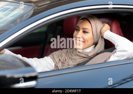 Cheerful muslim woman driving her new car Stock Photo