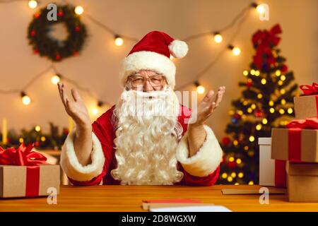 Happy Santa Claus talking on video call with kids using webcam on laptop. Christmas background. Stock Photo