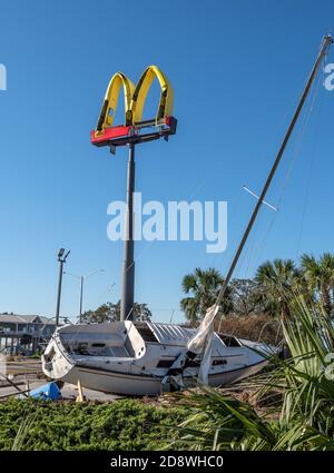 Hurricane Zeta wind damage and storm surge debris including a sailboat swept from harbor across Highway 90 at McDonalds in Long Beach, Mississippi. Stock Photo