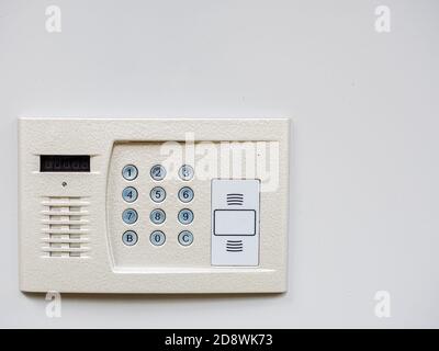 White metal intercom on a white wall. Object in the corner of the frame Stock Photo