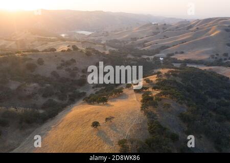 Evening sunlight shines on the rolling hills in Northern California. These beautiful, golden hills turn green once winter brings seasonal rains. Stock Photo