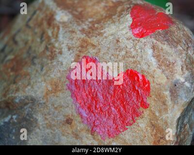 Bright Red Hearts Painted on Outdoor Rock Stock Photo