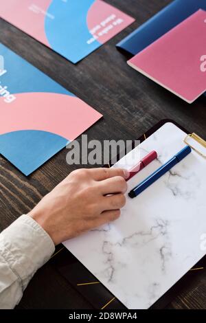 Hand of male manager or coach taking highlighter off blank paper in clipboard Stock Photo