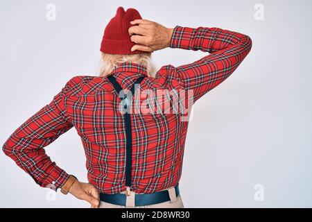 Old senior man with grey hair and long beard wearing hipster look with wool cap backwards thinking about doubt with hand on head Stock Photo