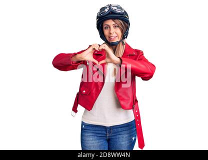 Young beautiful woman wearing motorcycle helmet smiling in love showing heart symbol and shape with hands. romantic concept. Stock Photo