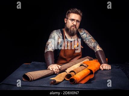 Craftsman produce a leatherwork at his desk Stock Photo