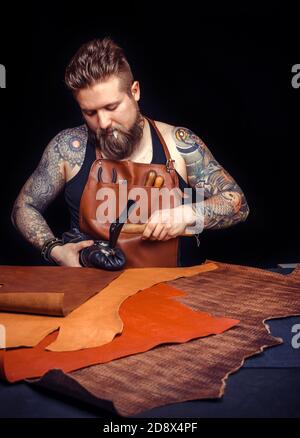 Leather Currier cuts out leather goods at his tanner shop Stock Photo