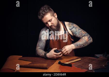 Tanner of leather produces leather goods at the studio Stock Photo