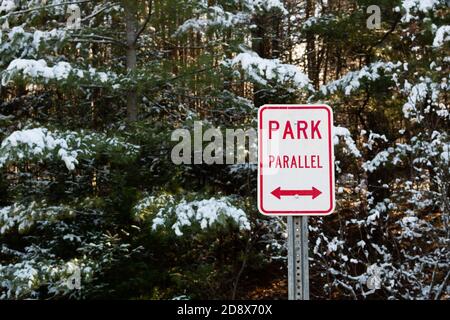 Red and white parallel parking sign on a wilderness parking lot in the Adirondack Mountains, NY USA in winter Stock Photo