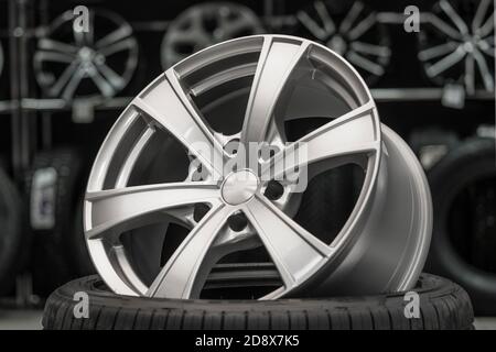 silver alloy wheel on a tire in a car spare parts store Stock Photo