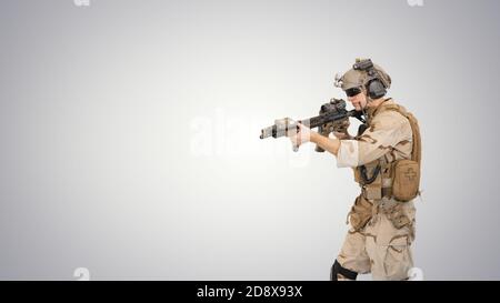 Medium shot. Walking in and out of the frame. United states ranger walking in, making hold gesture and then making go gesture on gradient background. Stock Photo