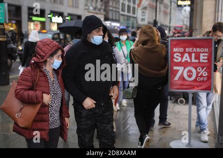London, Britain. 1st Nov, 2020. Shoppers look in a store window on Oxford Street in London, Britain, on Nov. 1, 2020. British Cabinet Office Minister Michael Gove on Sunday admitted the month-long lockdown, which will be imposed in England on Thursday, could be extended if rates of infection do not fall sufficiently. Gove made the statement after British Prime Minister Boris Johnson announced the new restrictions, which are set to last until Dec. 2, at a press conference from Downing Street on Saturday. Credit: Tim Ireland/Xinhua/Alamy Live News Stock Photo