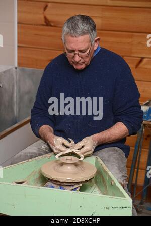 GREYMOUTH, NEW ZEALAND, AUGUST 11, 2020: A potter uses a pair of calipers to check the diameter of the lid he his throwing on a pottery wheel. Stock Photo