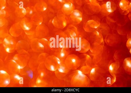 Defocused lights. Bright orange flat hexagon lights bokeh on black background. Golden glitter Christmas abstract background. Stock Photo