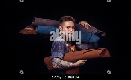Worker of leather cuts out leather goods in a workshop Stock Photo