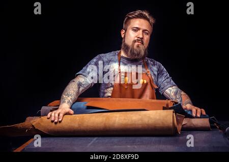 Skinner cutting out leather shapes for a new product Stock Photo