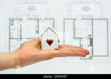 A hand holding toy house as a symbol of a new house idea or concept. Stock Photo