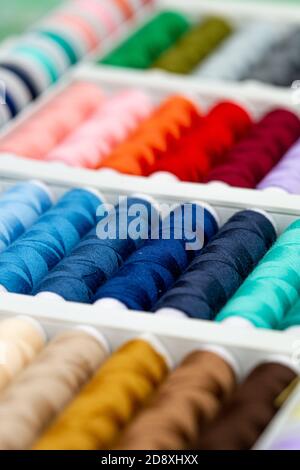 A set of threads in different colors. Multicolored threads for sewing and needlework. Small rolls of thread in a different colours.  Stock Photo