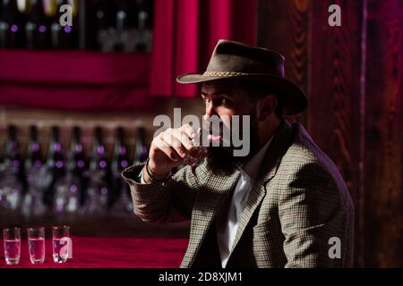 Degustation and tasting. Man with beard holds glass of brandy. Stock Photo