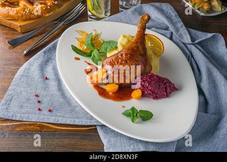 Duck leg on a rustic table in a cozy pub Stock Photo