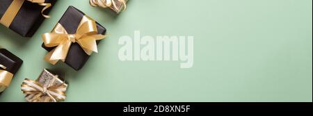 Seafoam green paper banner with black gift boxes and golden bows. Shopping Discount promotion Stock Photo