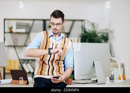 Entrepreneur checking smartwatch Stock Photo