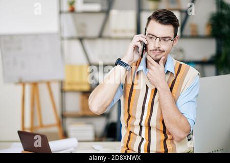 Pensive man talking on phone Stock Photo