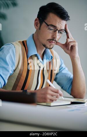 Man writing in journal Stock Photo