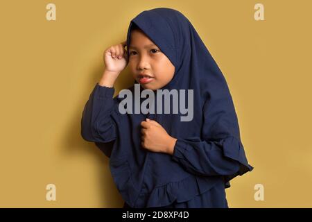 Portrait of a little asian muslim hijab girl thinks Stock Photo