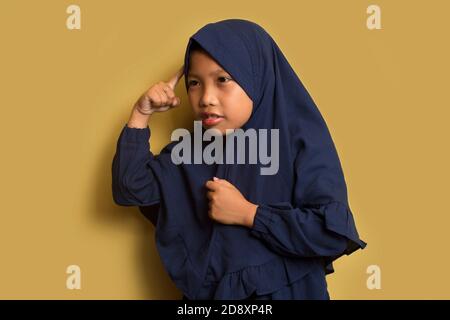 Portrait of a little asian muslim hijab girl thinks Stock Photo