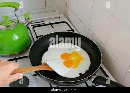Closeup eggs being fried in a pan and some broken, for the concept of amateur cook Stock Photo