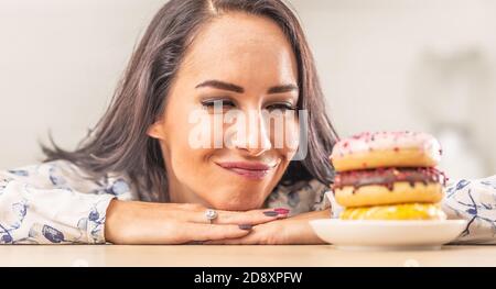 Woman passionately looking forward to eat a pile of doughnuts. Stock Photo