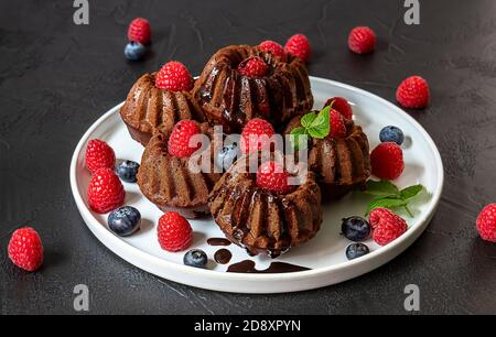 Mini chocolate cakes with chocolate and fresh berries Stock Photo