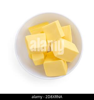 Butter pieces in bowl isolated on white background, top view. Fresh butter chunks  close up Stock Photo