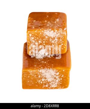 Caramel candies and sweet sauce isolated on white background, top view. Homemade salted caramel pieces Stock Photo