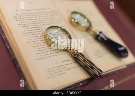 Two Magnifying Glasses Resting on a Book. Stock Photo
