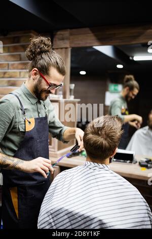 Client during beard shaving in barber shop Stock Photo